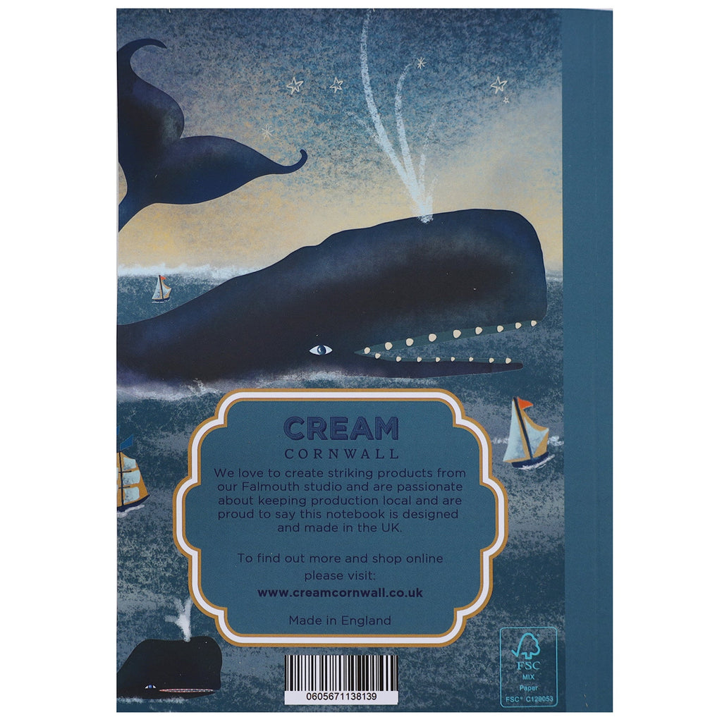 Back cover of a notebook featuring an illustrated whale spouting water under a starry sky, with sailboats on a dark sea. A label in the center reads "CREAM Cornwall" with information about the brand's local UK production and website details.