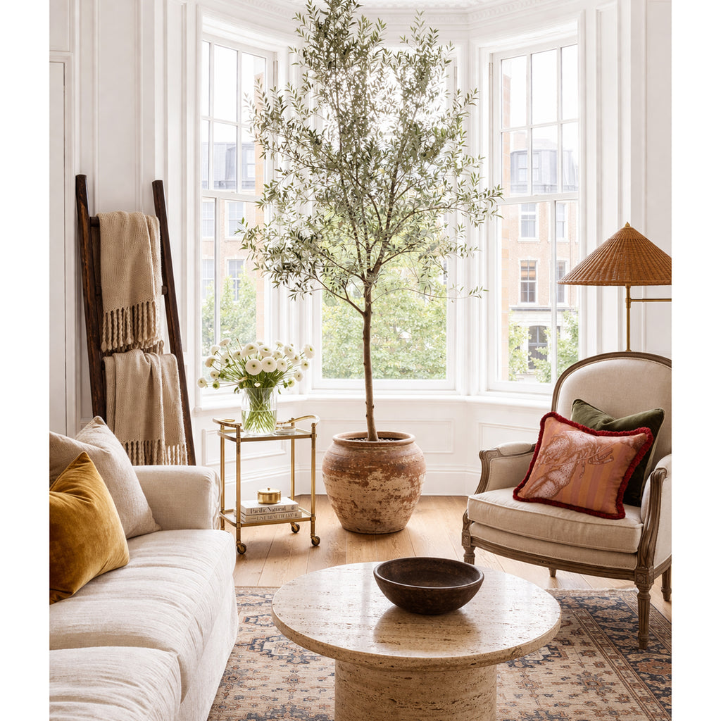 Living room with a large window, sofa, armchair, and decorative items.