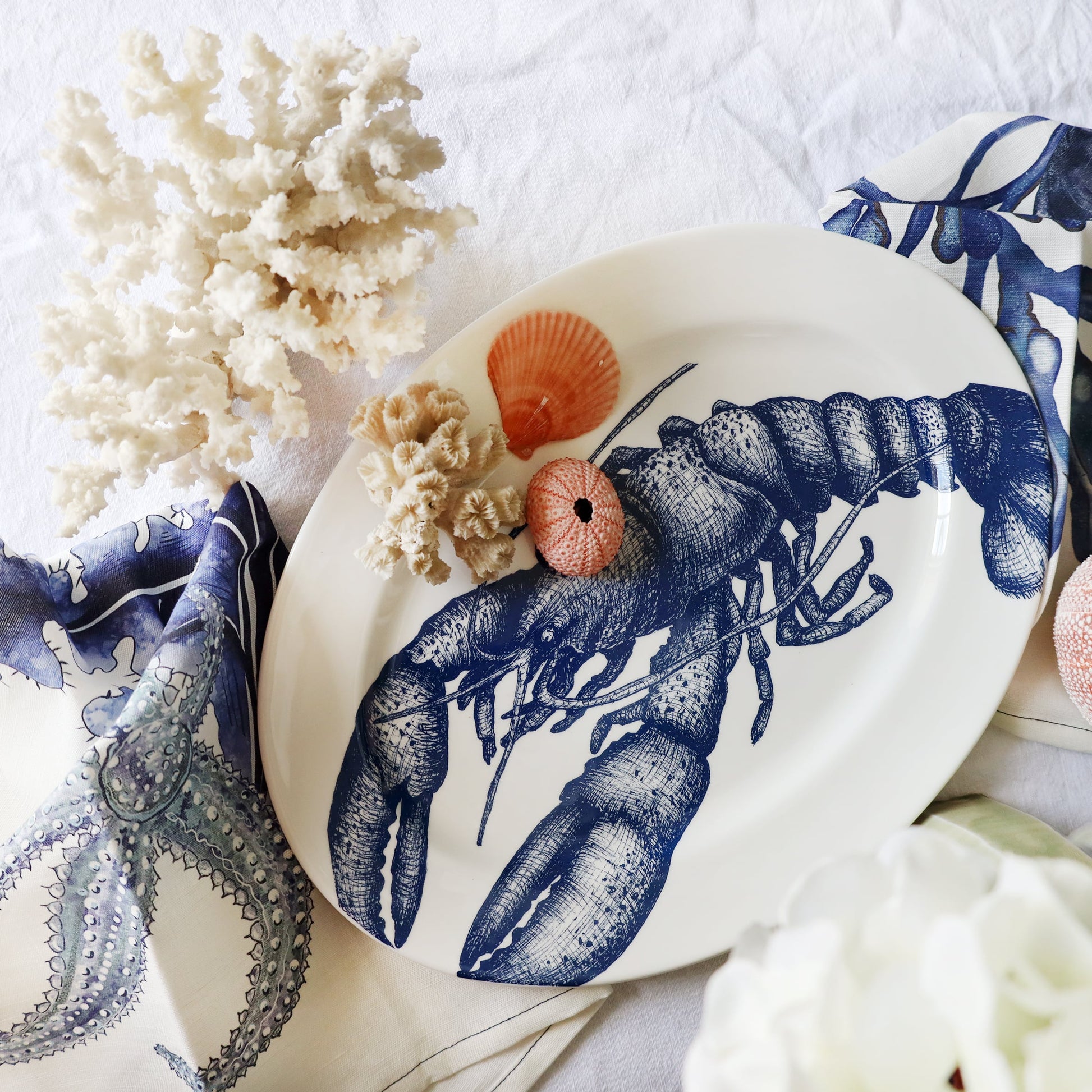 Ceramic plate with a blue lobster design on a white surface with decorative elements.