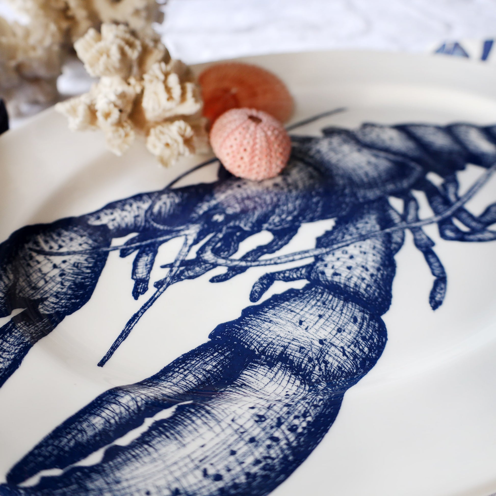 Decorative plate with a blue lobster design on a white background