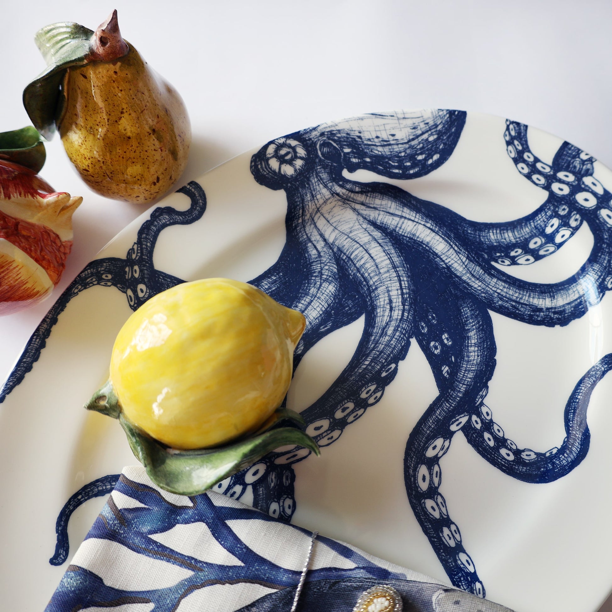 Decorative plate with blue octopus design featuring a yellow lemon on a white background