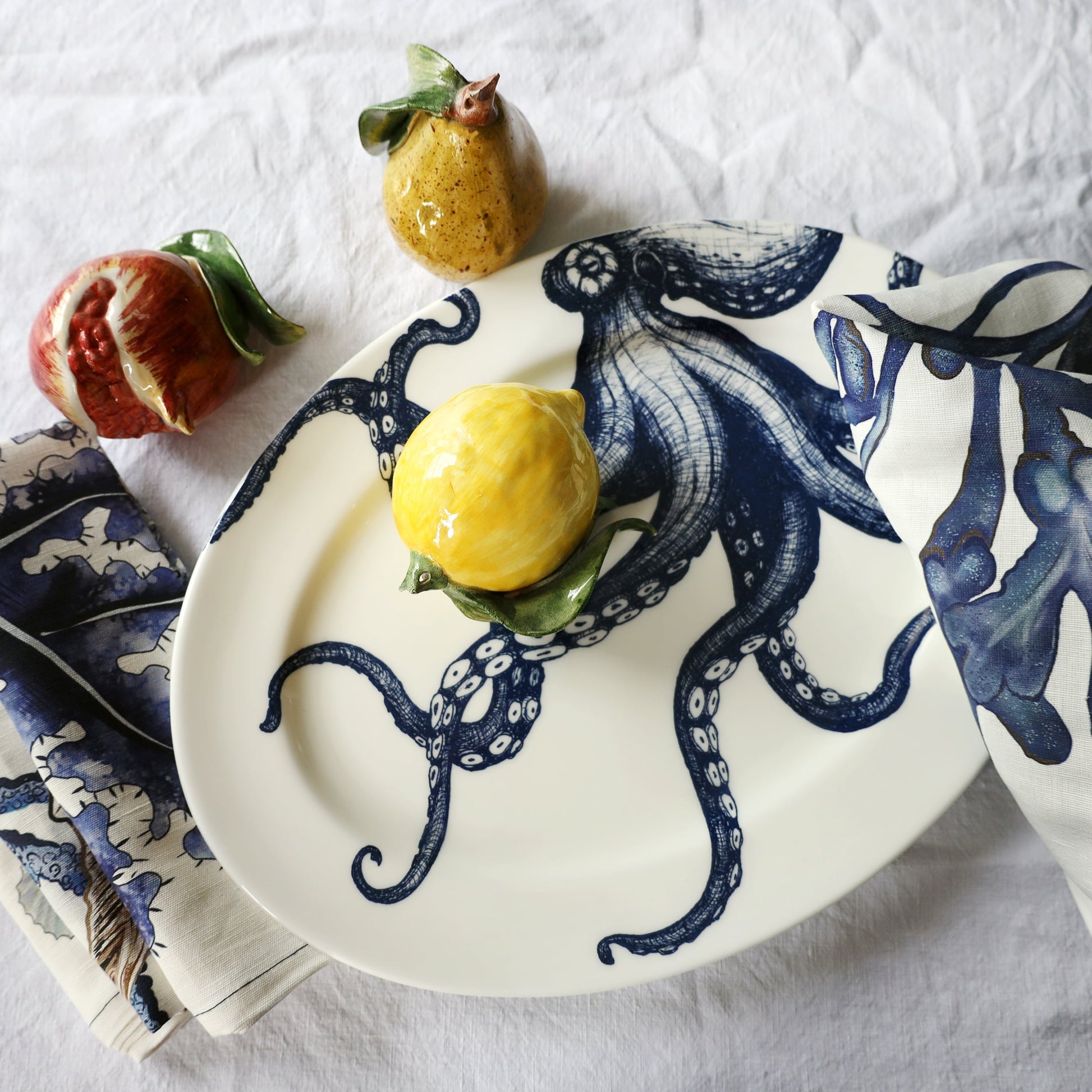 Decorative plate with blue octopus design featuring a lemon and fig on a white background
