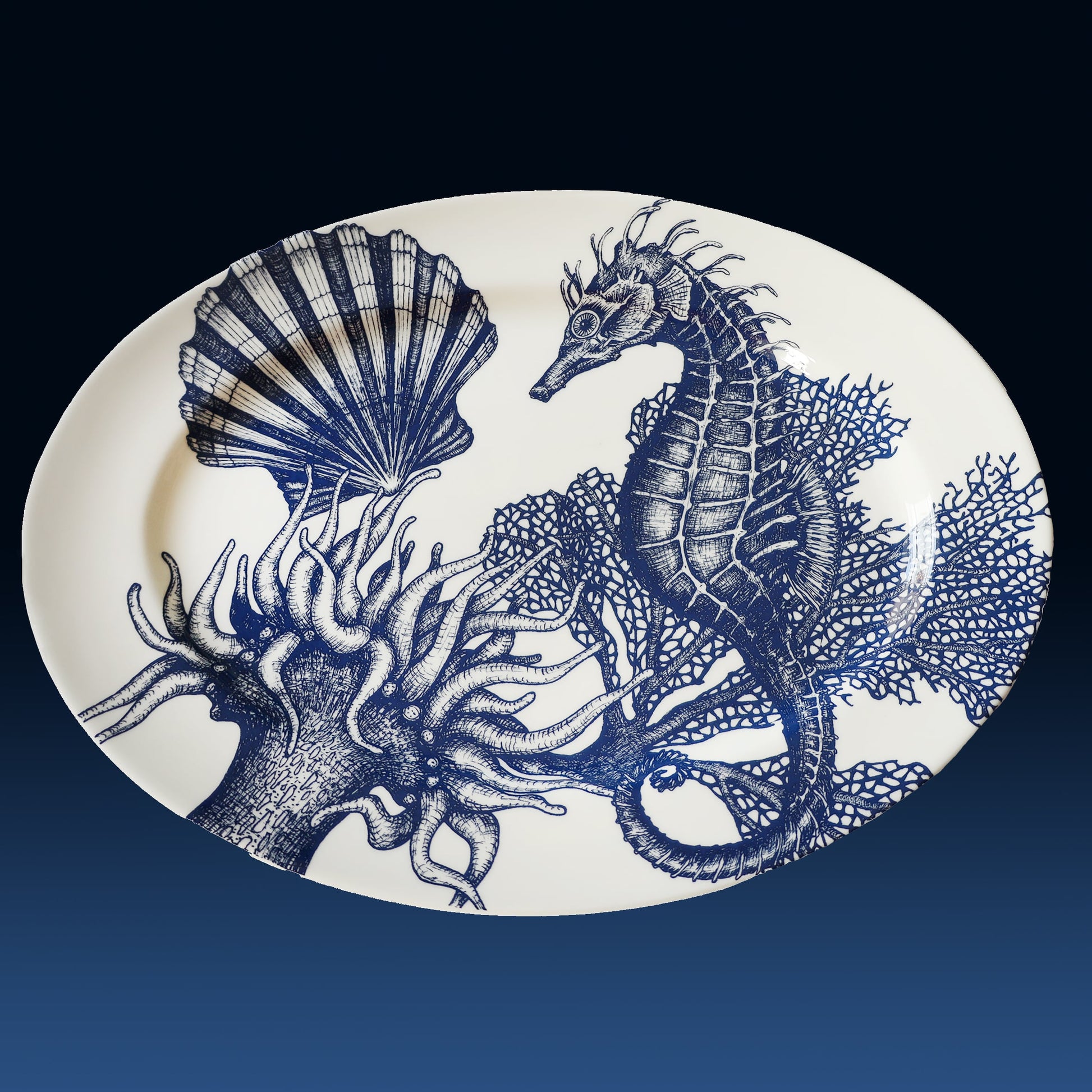 Decorative plate with blue seahorse and shell design on a white background