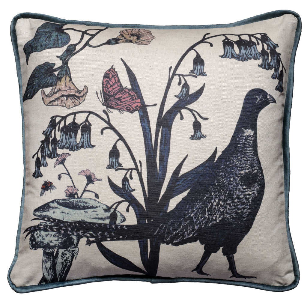 Square cushion featuring a vintage-style print of a pheasant standing among bluebells and wildflowers. The design includes detailed illustrations of a butterfly and a small insect on a natural linen-coloured background, bordered with a soft blue velvet piping.