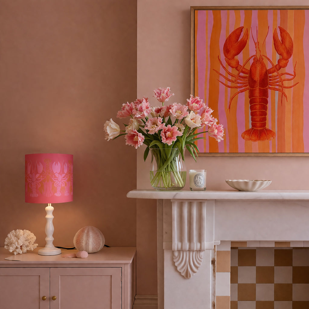 Decorative room interior with a vase of flowers, lamp, and artwork on a wall.