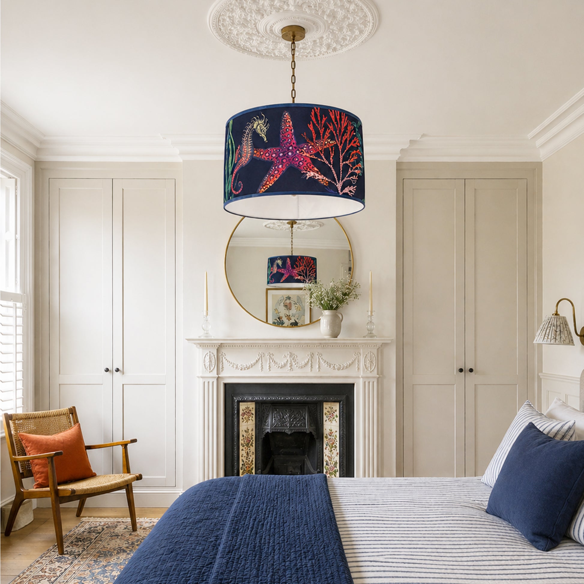 Neatly decorated bedroom with a fireplace, lamp, and furniture.