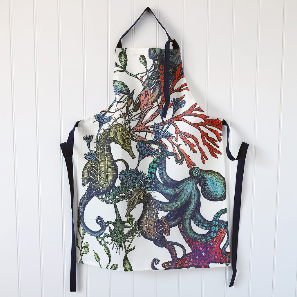 White Linen/Cotton mix apron with navy ties and Navy strap around the neck,this can be adjusted to fit.On the print is our coloured reef design.