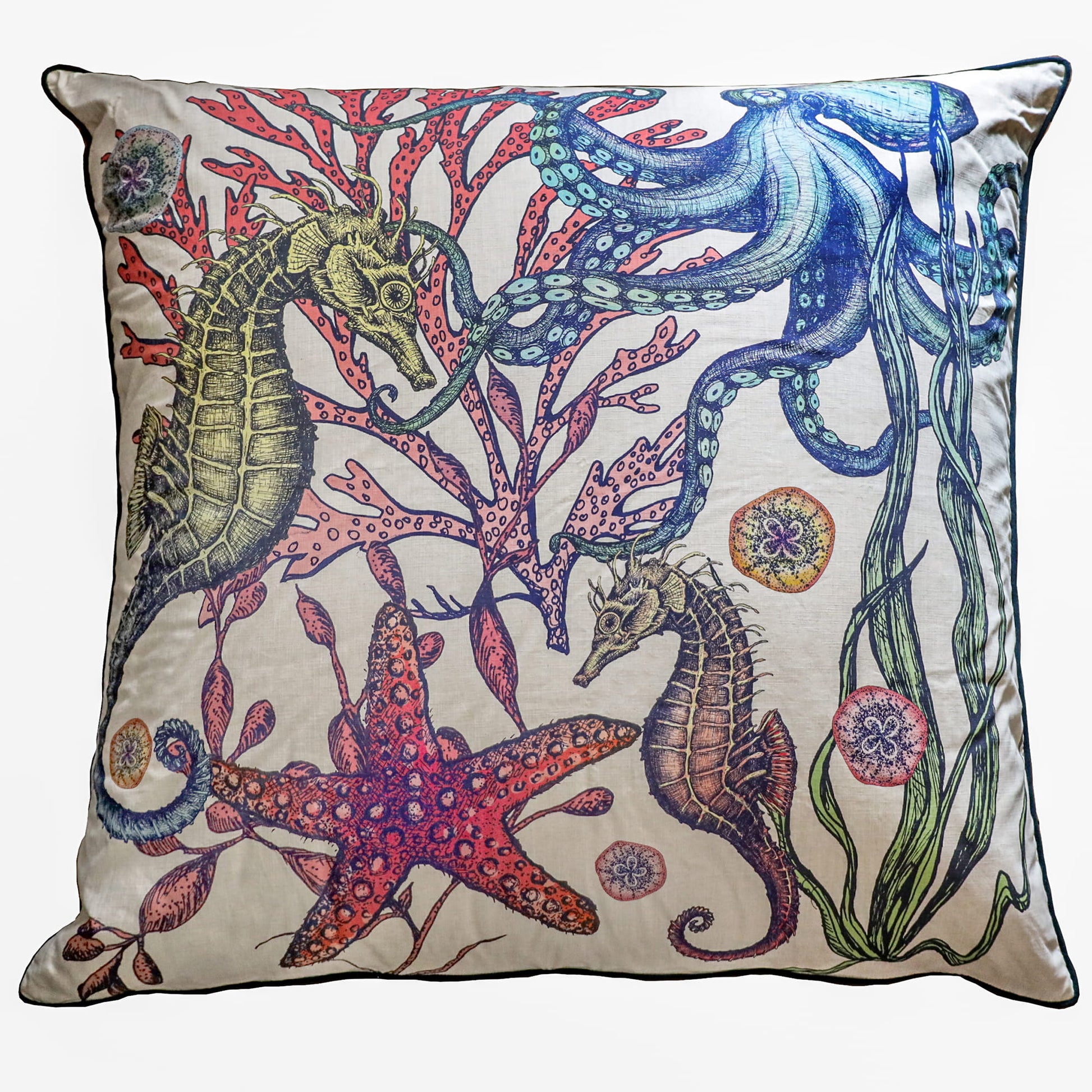 Decorative pillow with sea-themed design featuring seahorses, starfish, and seaweed on a beige background.