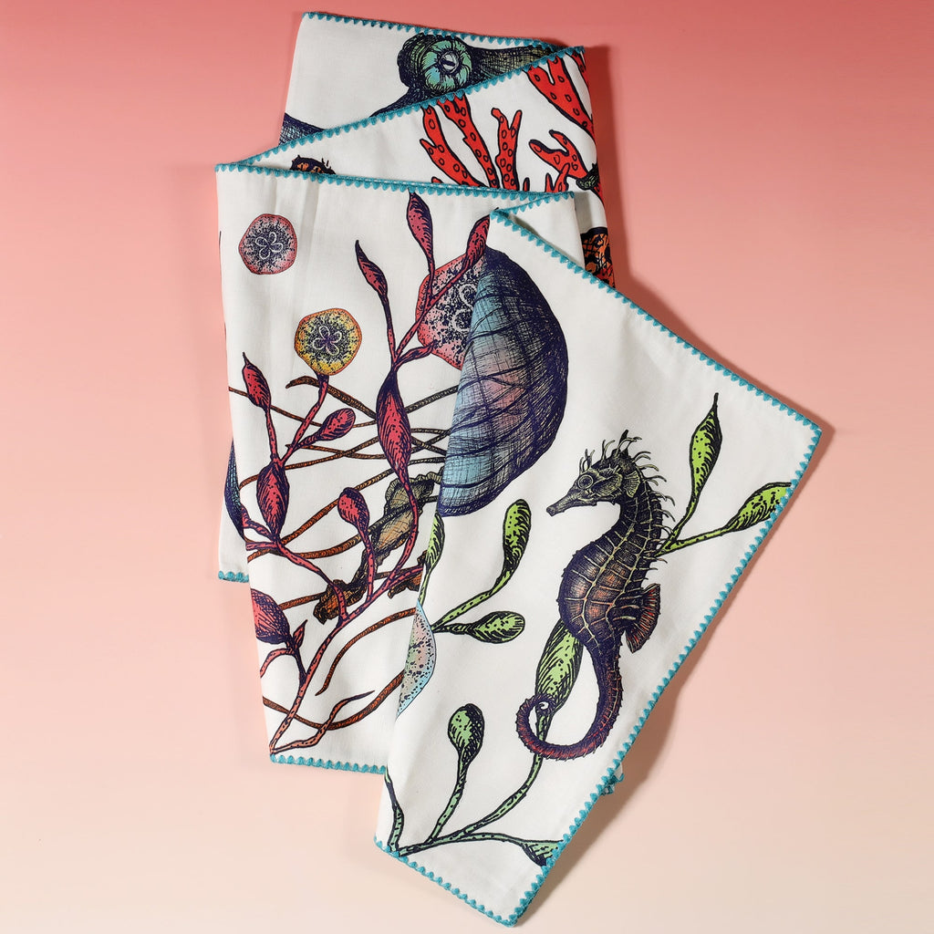 Cotton and Linen mix table runner with hand drawn illustrations with our Reef design with Seahorses,Octopus,Jellyfish,Starfish in the seaweed.Side edge is finished with a turquoise embroidery