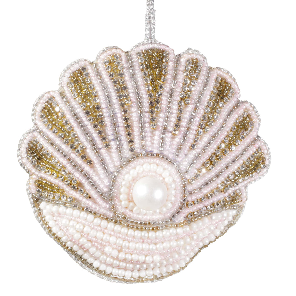 Decorative shell ornament with pearls and beads on a white background