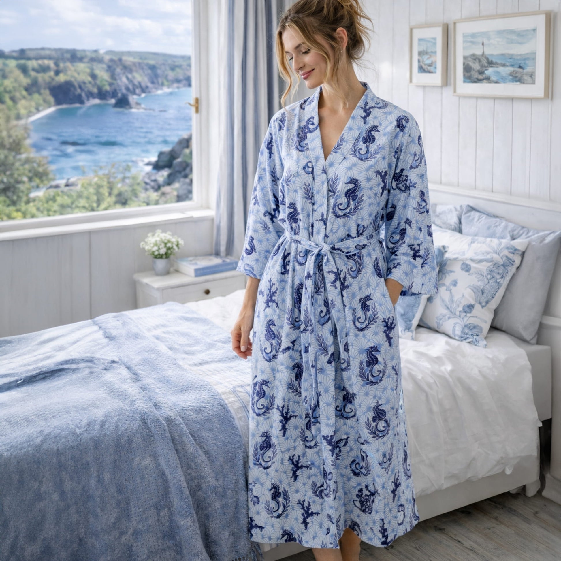 Woman wearing a blue patterned robe in a bedroom with a scenic view.