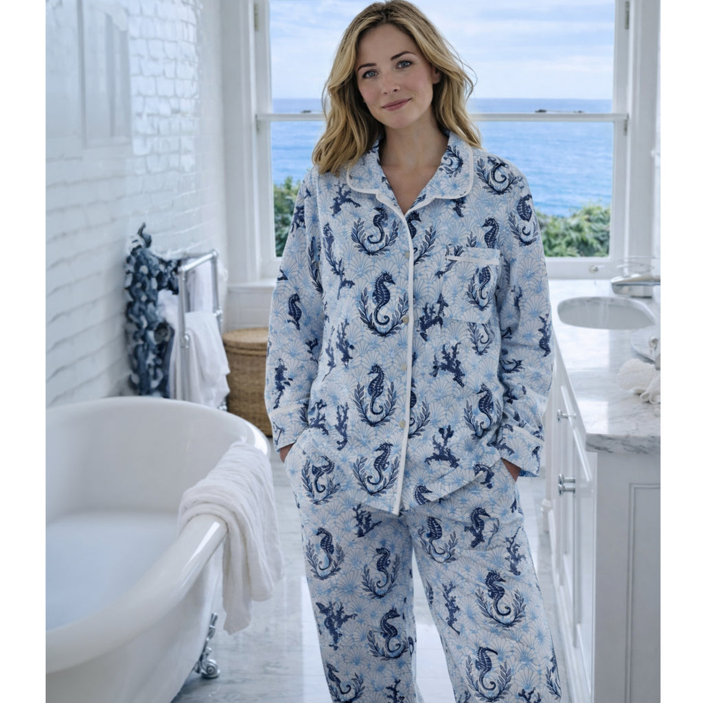Woman wearing a blue and white pajama set with a seahorse pattern in a bright room.