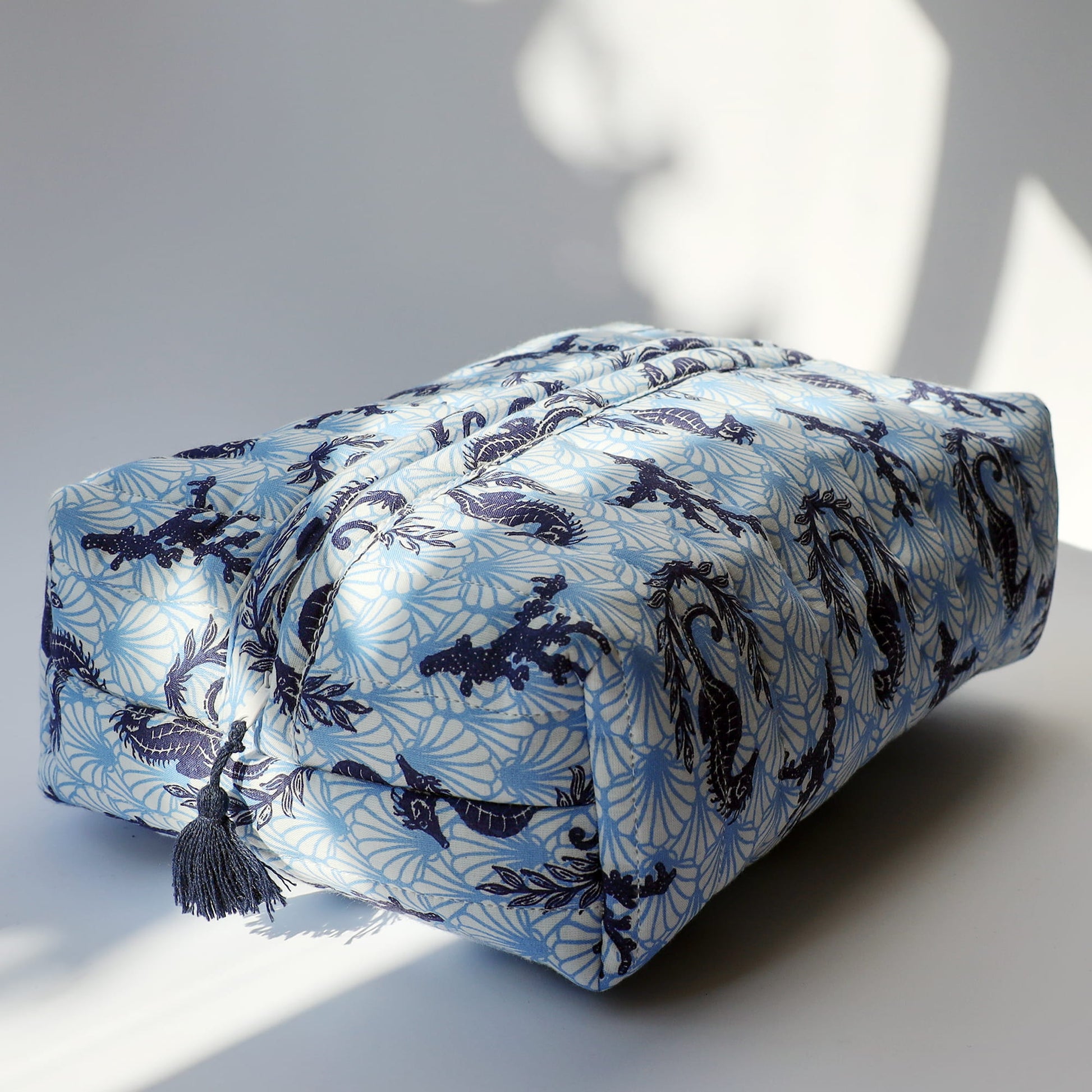 Rectangular fabric was bag with blue and navy shell & seahorse pattern on a light background