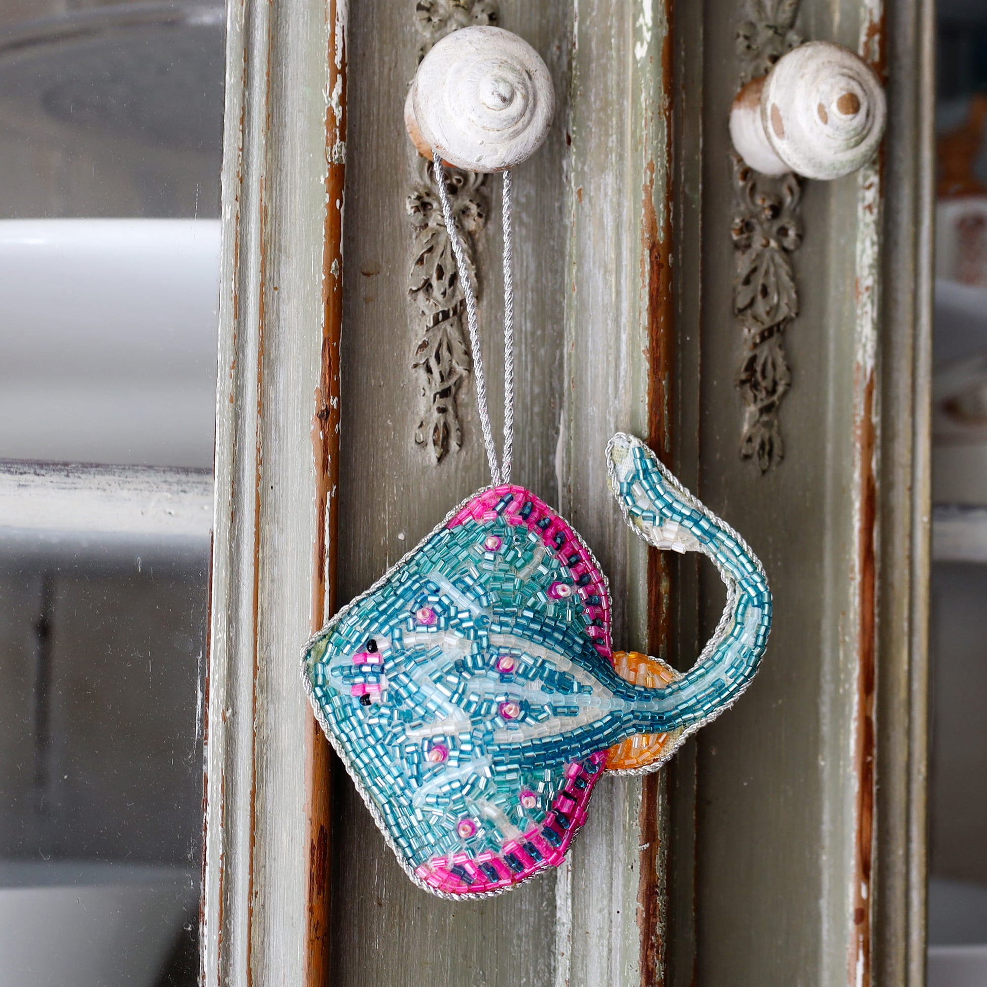 Decorative stingray ornament hanging on a textured wall.