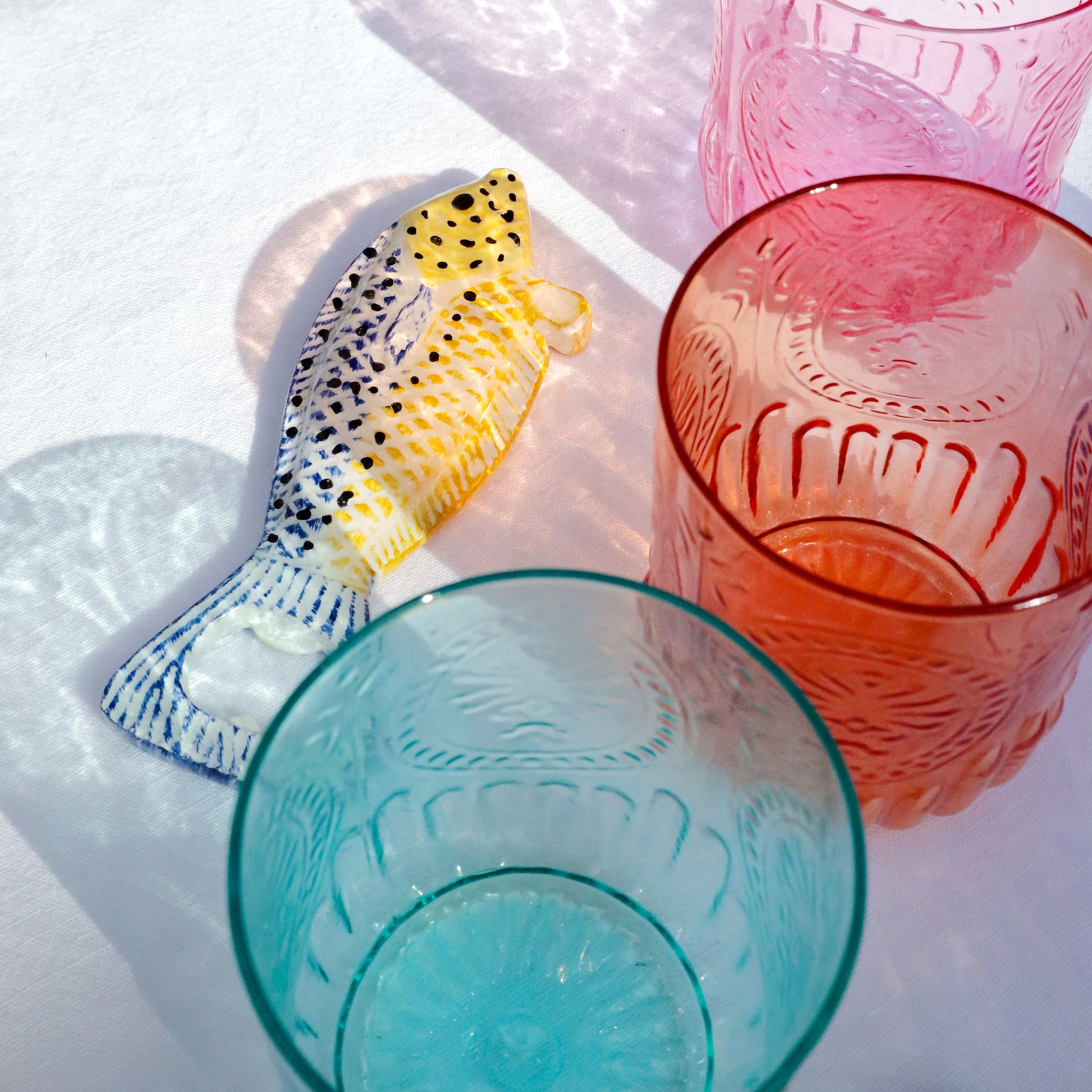 Colorful glass tumblers with textured designs on a white surface