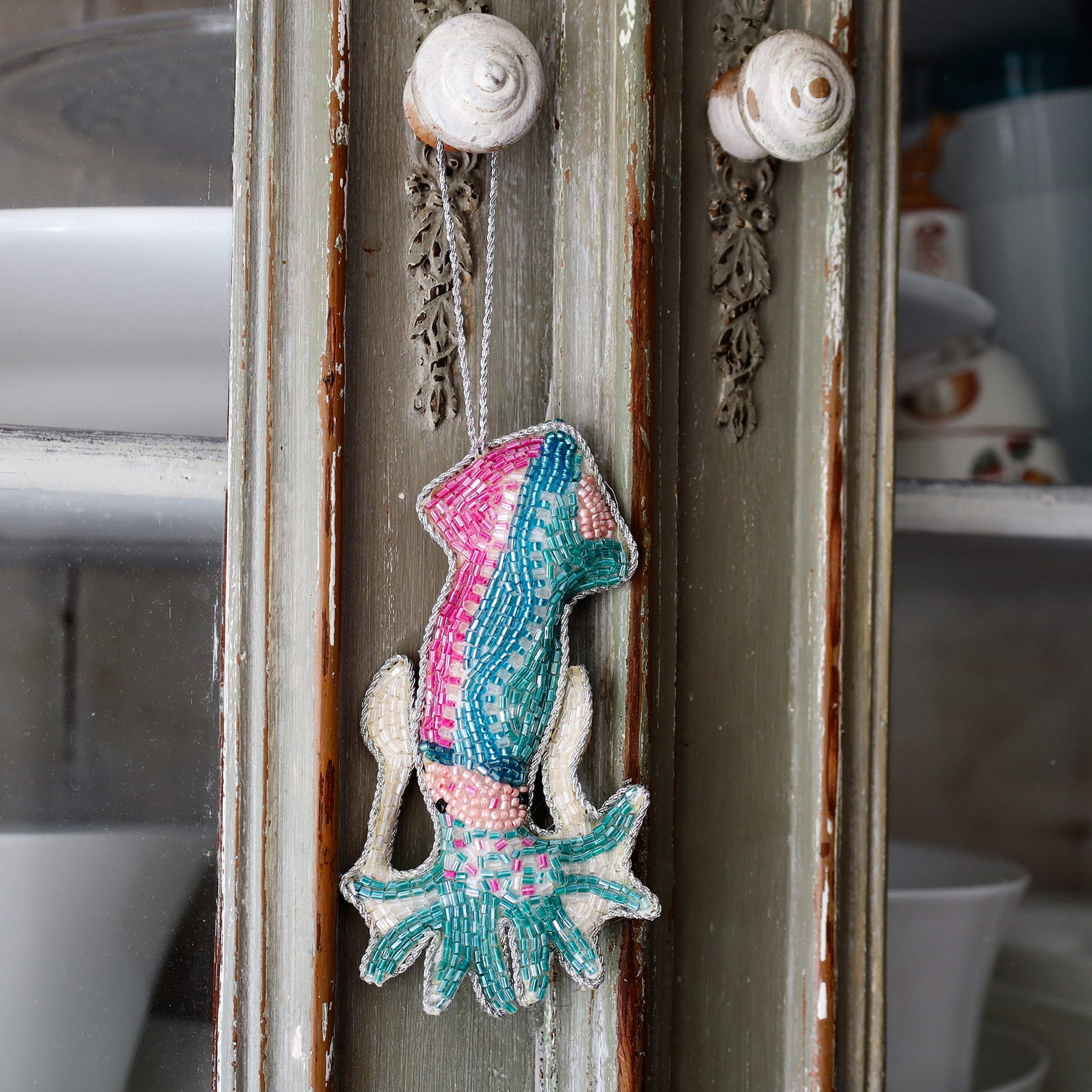 Decorative squid ornament on a textured wall with a blurred kitchen background