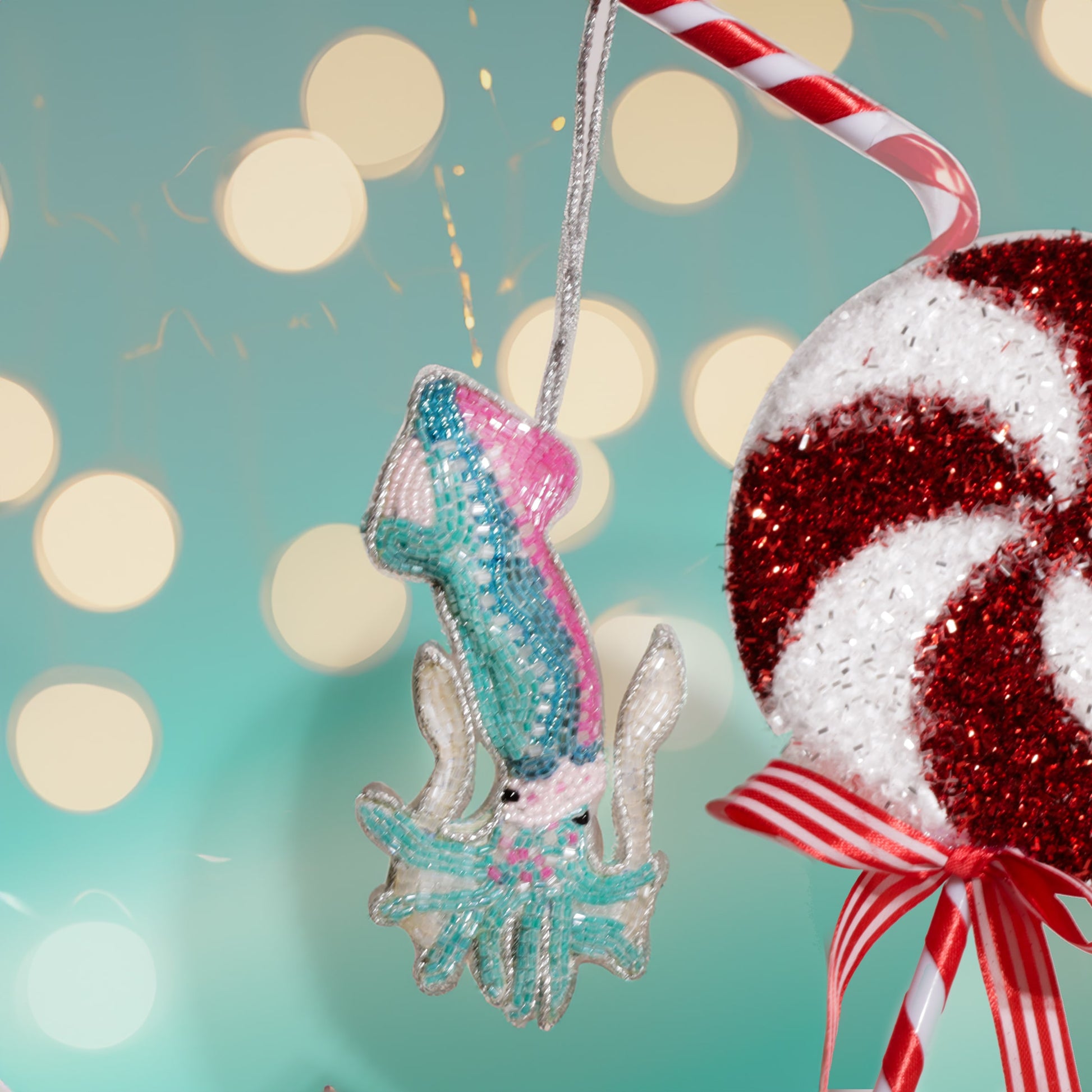 Decorative Christmas ornaments including a glittery squid and candy cane against a festive background.