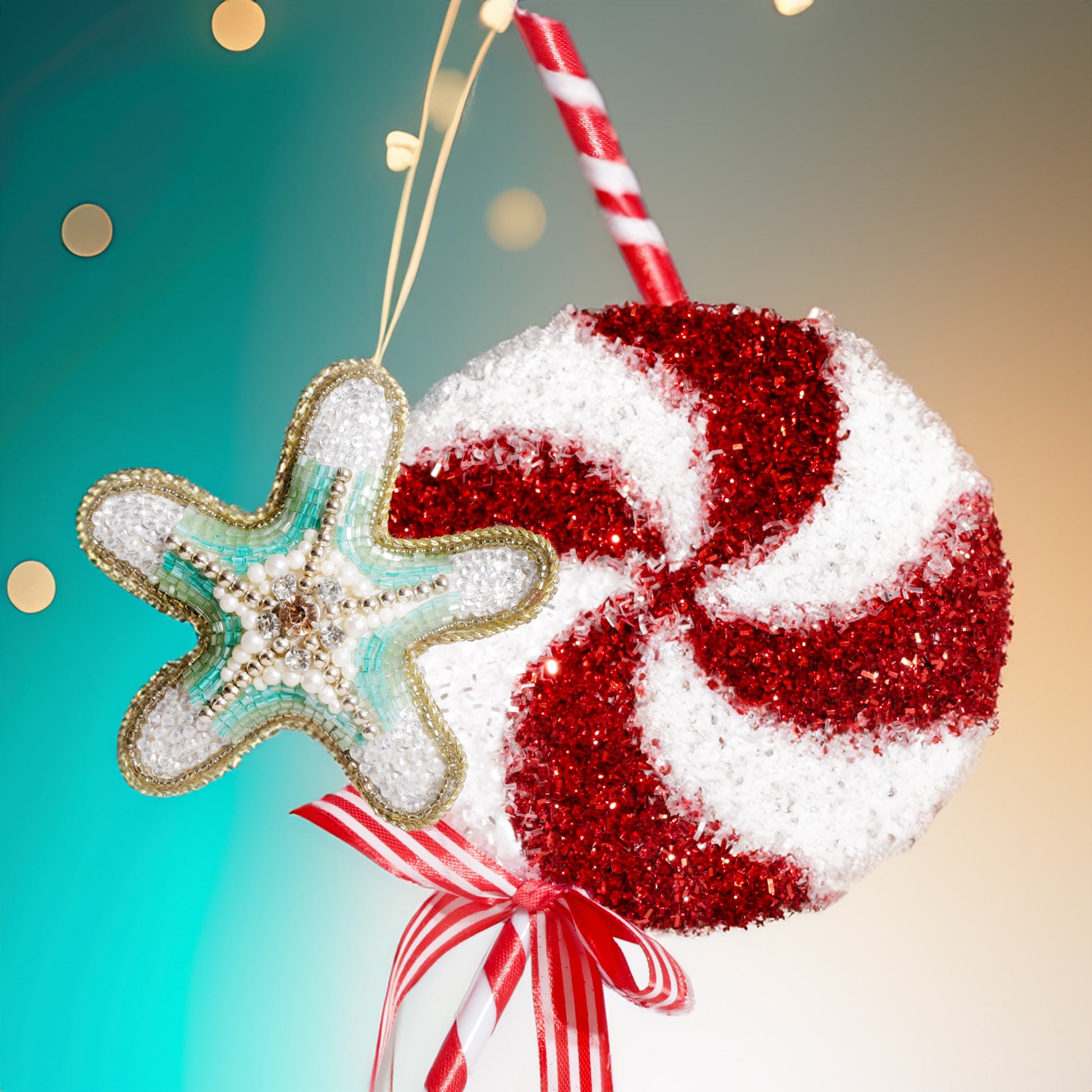 A turquoise and white beaded starfish decoration with pearl and crystal accents, hanging beside a large red and white glittery peppermint lollipop tied with a red striped ribbon