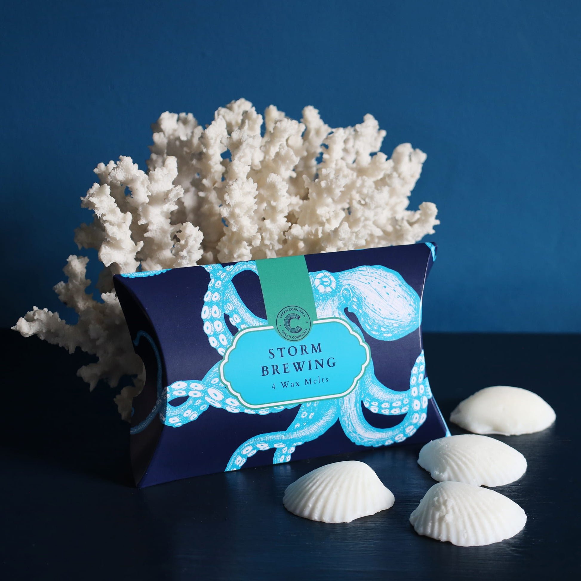 Cream Cornwall storm brewing wax melts in nautical-themed product packaging with coral and shells on a blue background