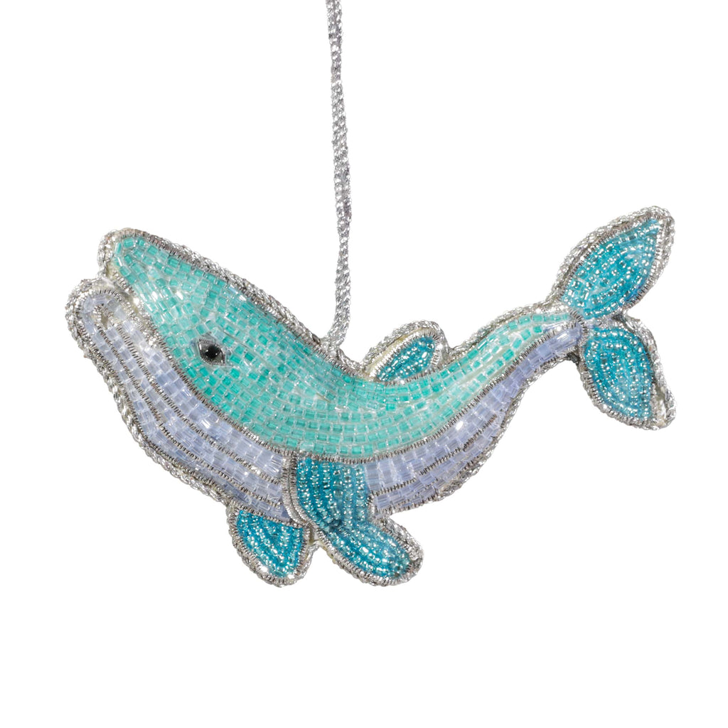 Decorative whale ornament with turquoise and silver design on a white background