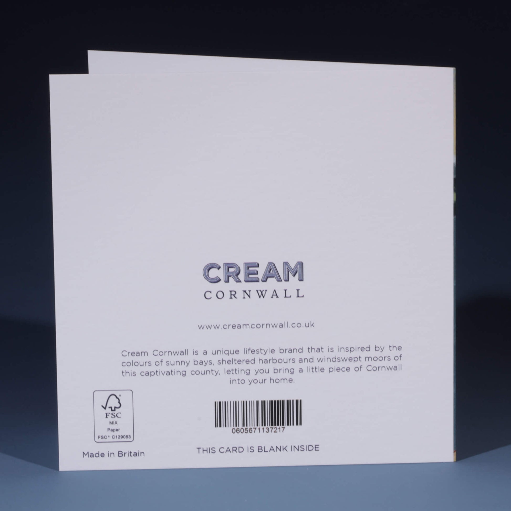 The back of a Cream Cornwall greeting card, featuring the brand's logo and website, www.creamcornwall.co.uk. The text describes the brand as inspired by the colors of Cornwall's sunny bays, sheltered harbors, and windswept moors. An FSC-certified paper symbol is visible in the bottom left corner, along with a barcode. The message at the bottom states, 'THIS CARD IS BLANK INSIDE,' and the card is labeled 'Made in Britain.'