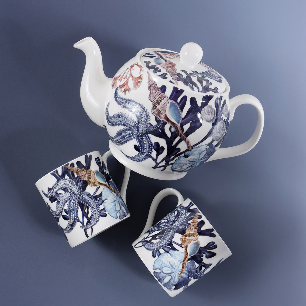 The photo is of a Beachcomber teapot and two Beachcomber mugs next to it, sitting on a blue graduated background.