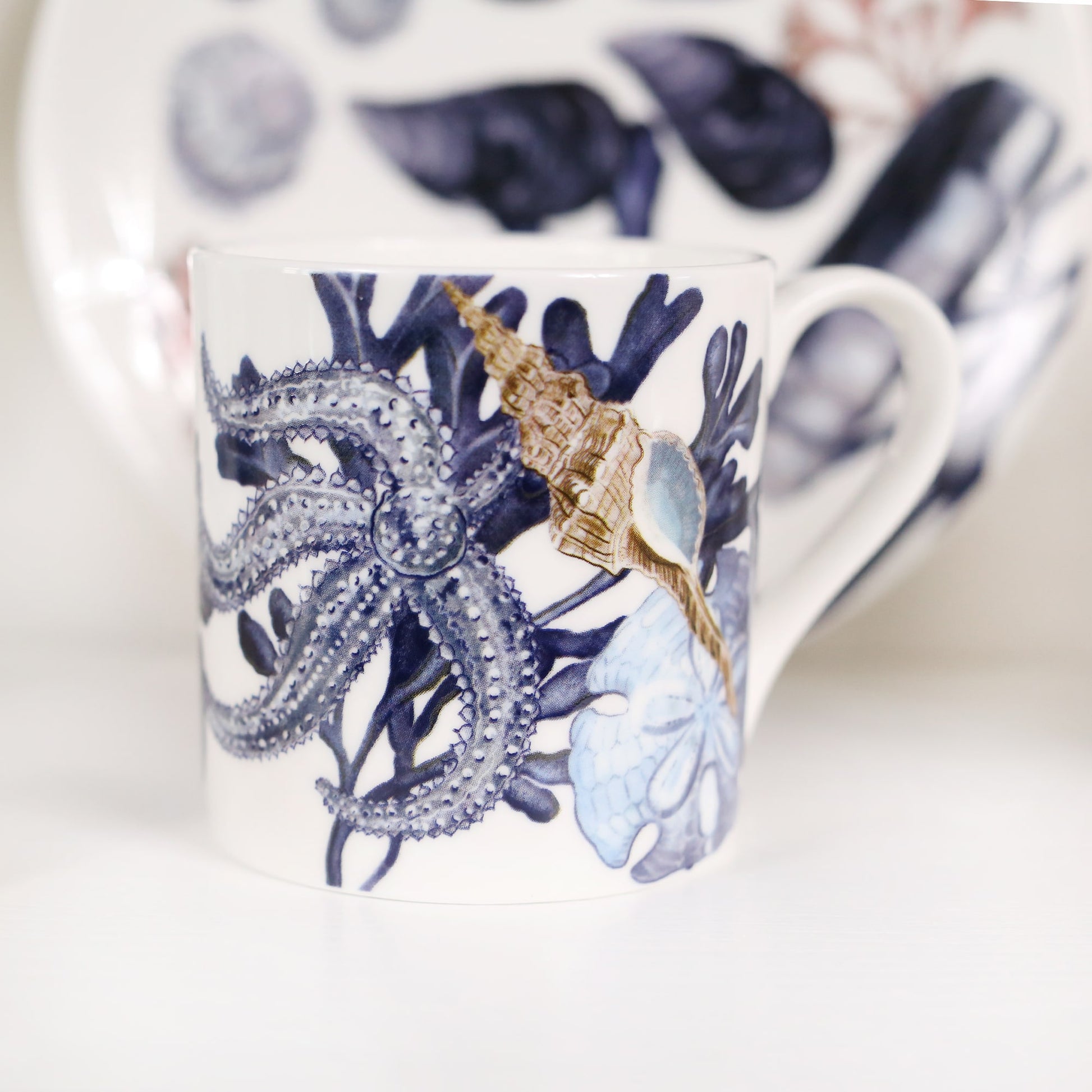The photo shows a close up of a beachcomber mug with a Beachcomber plate out of focus in the background