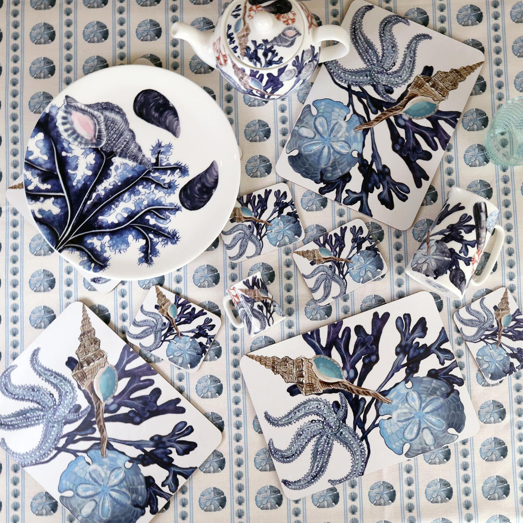 Tablecloth in the sand dollar with Placemats in our Beachcomber design with a matching coaster,a plate and a Beachcomber Teapot.