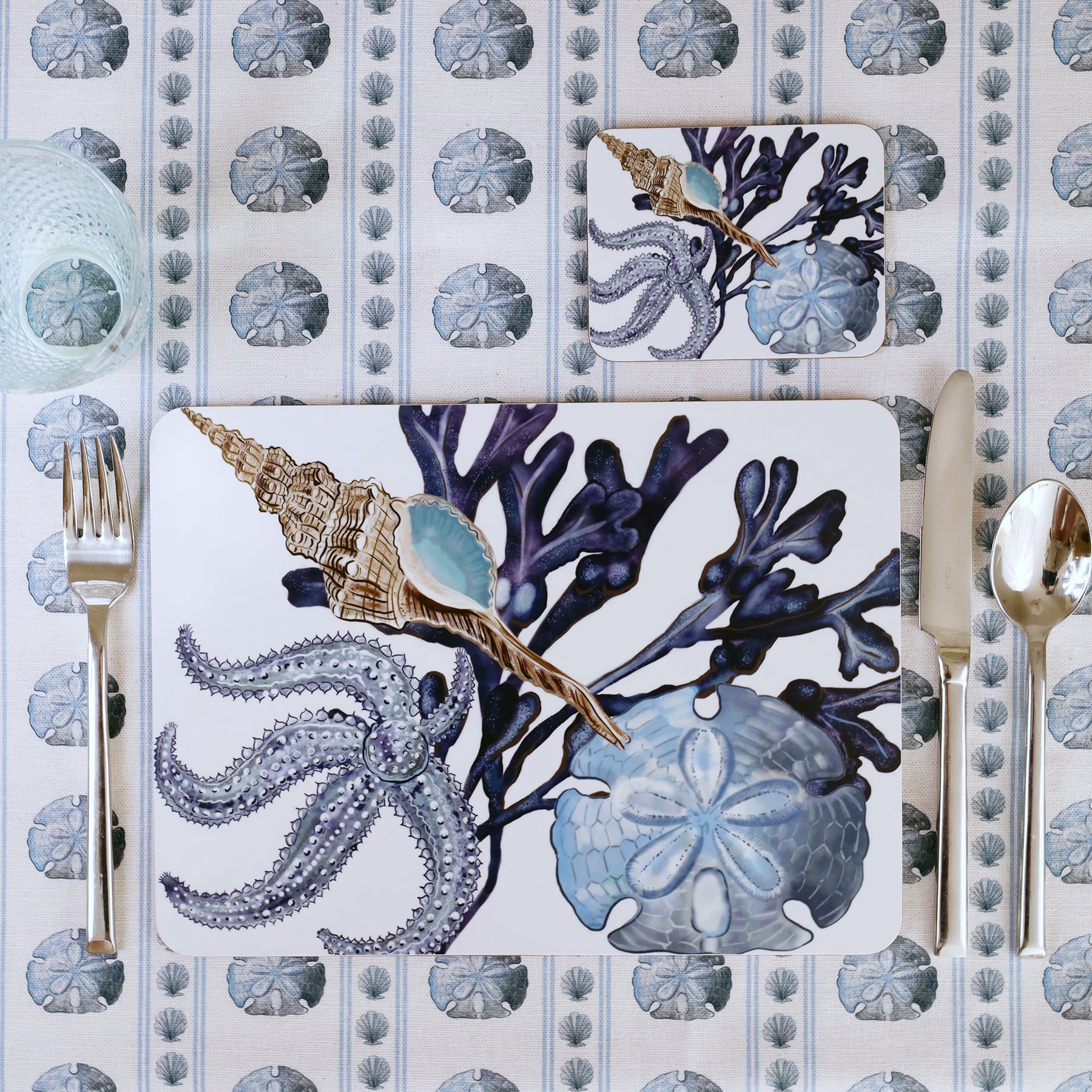 Tablecloth in the sand dollar showing a Placemat in our Beachcomber design with a matching coaster in a place setting.