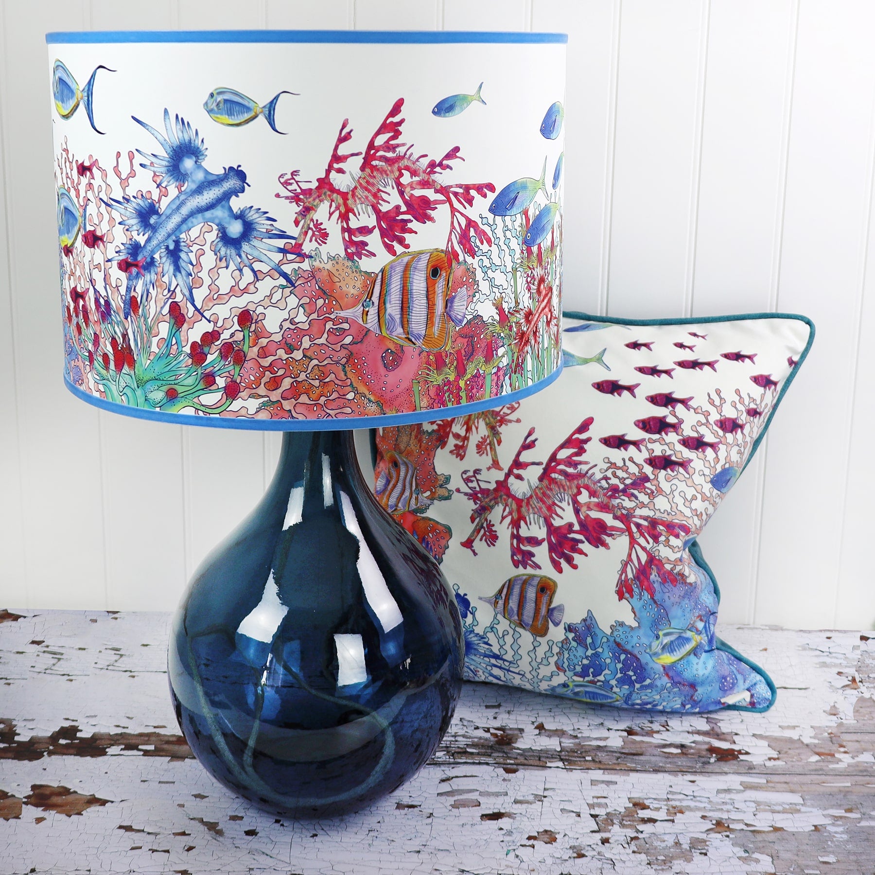 Coral Bay design lampshades in White on a glass lampbase in front of a White Coral Bay cushion