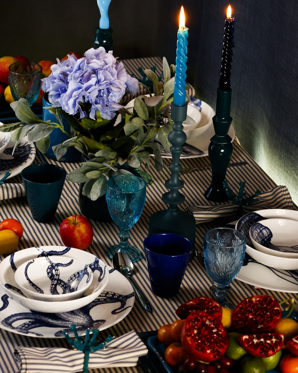Pasta bowl in Bone China in our Classic range in Navy and white in the Octopus design,placed on a matching dinner plate and has a smaller bowl placed inside.This is placed on a stripe tablecloth with various other tableware around the edge,with several lighted candles