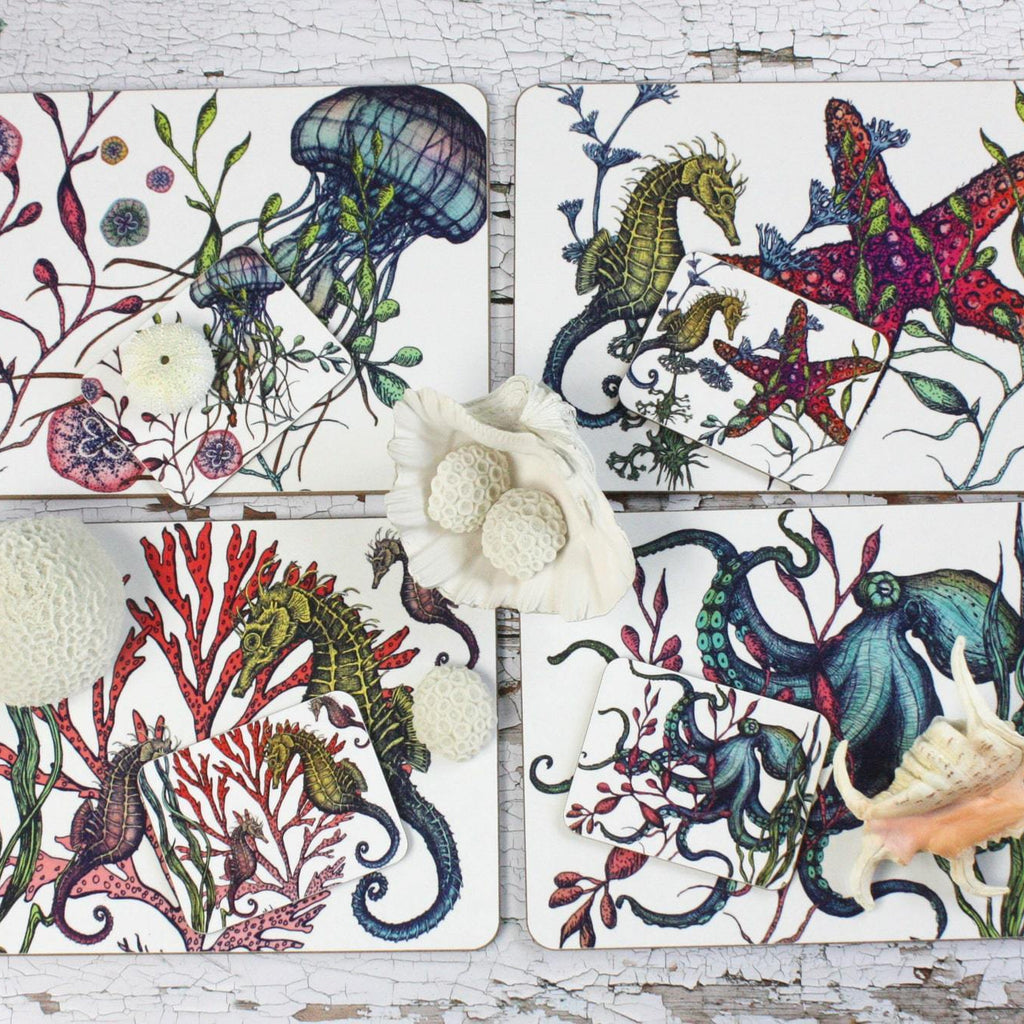 Set of four different coasters in our Reef coloured design with an Octopus,Seahorse,Jellyfish and a Starfish design with matching Placemats.All placed on a table decorated with various shells.