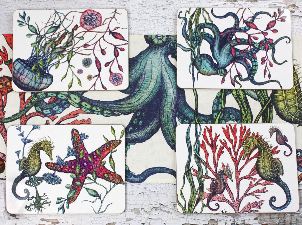 Set of four different coasters in our Reef coloured design with an Octopus,Seahorse,Jellyfish and a Starfish design with matching Placemats.All placed on a table on a matching table runner.